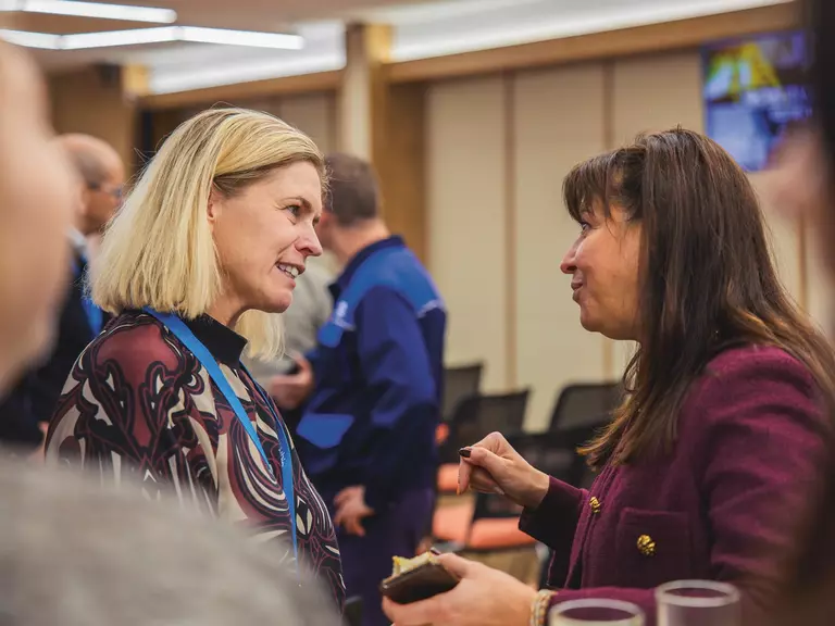 Conversation between two women during an event