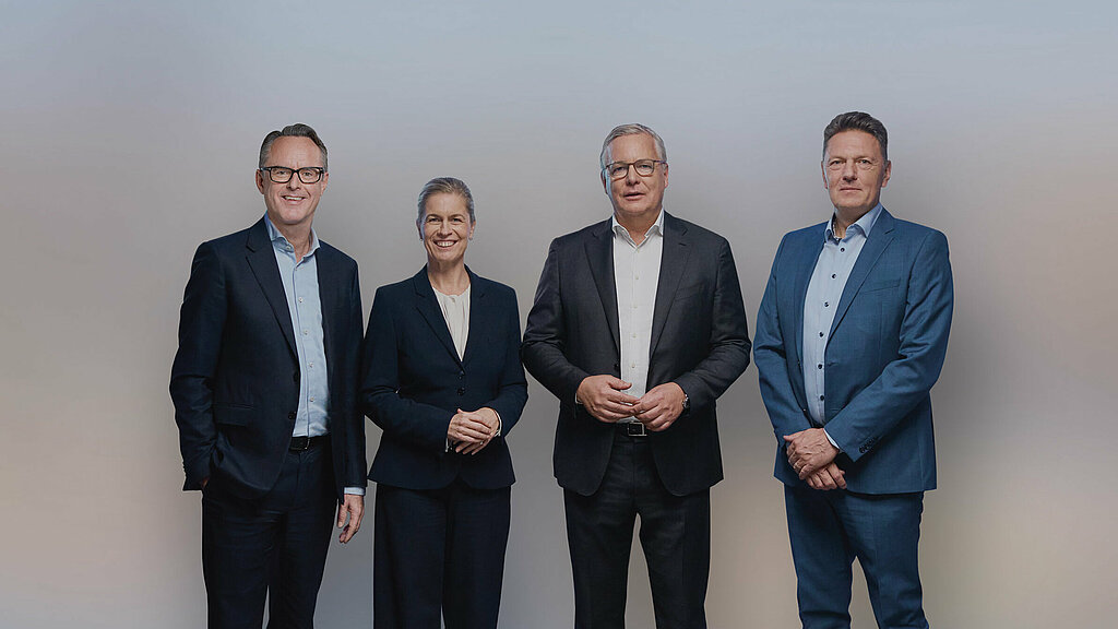 Group photo with Steffen Hoffmann (CFO), Inge Hofkens (COO), Dr Toralf Haag (CEO), Tim Kurth (COO) in black suit and dress