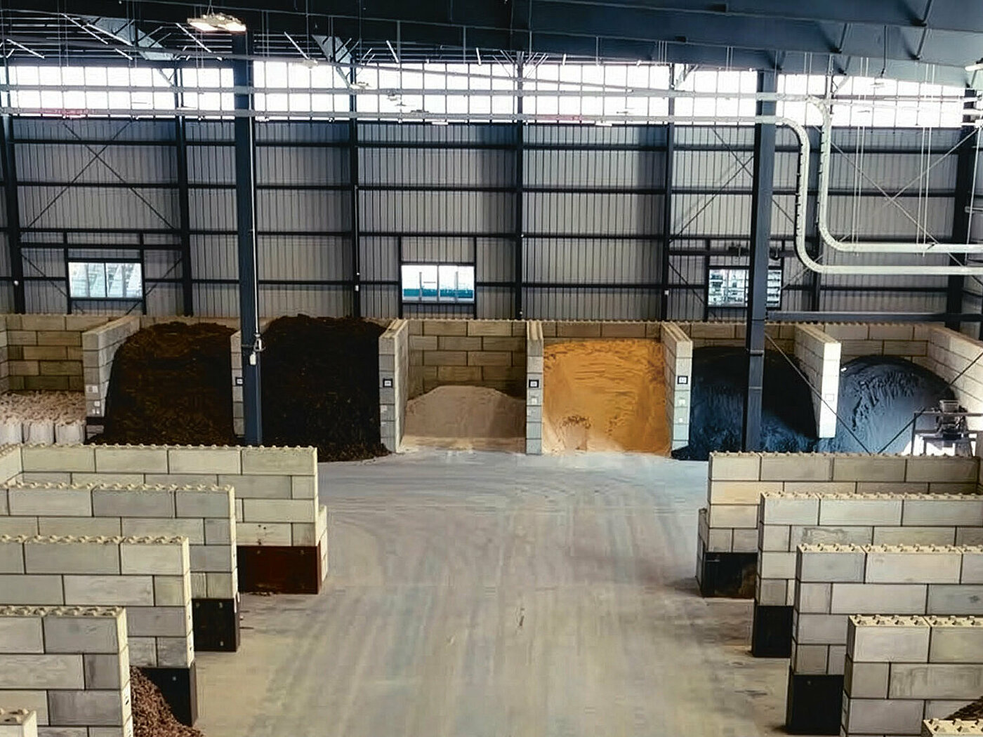 Warehouse with compartments separated by stone walls, in which different raw materials are stored