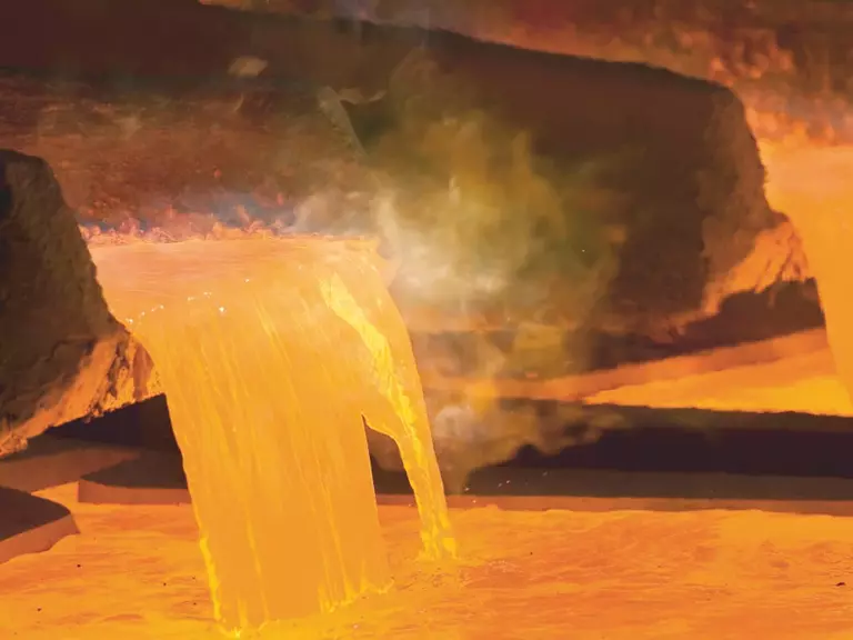 Hot liquid copper being poured into a steaming basin
